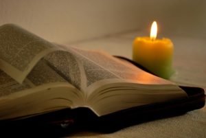 Image of candle illuminating a Bible